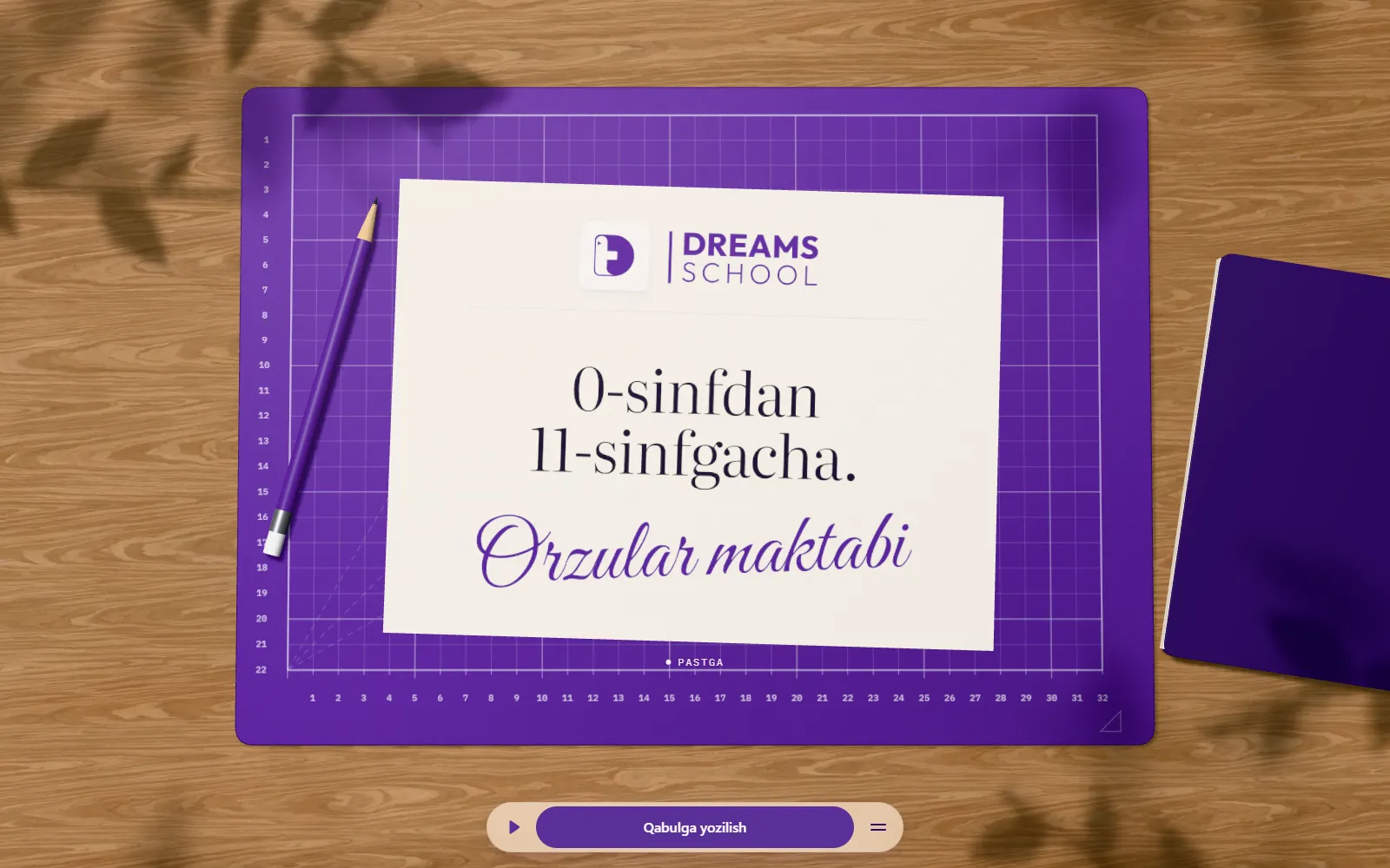Dreams School saytining bosh ekrani: yogʻoch stol ustidagi binafsha chizma gilamchasida “0-sinfdan 11-sinfgacha. Orzular maktabi” yozilgan varaq.